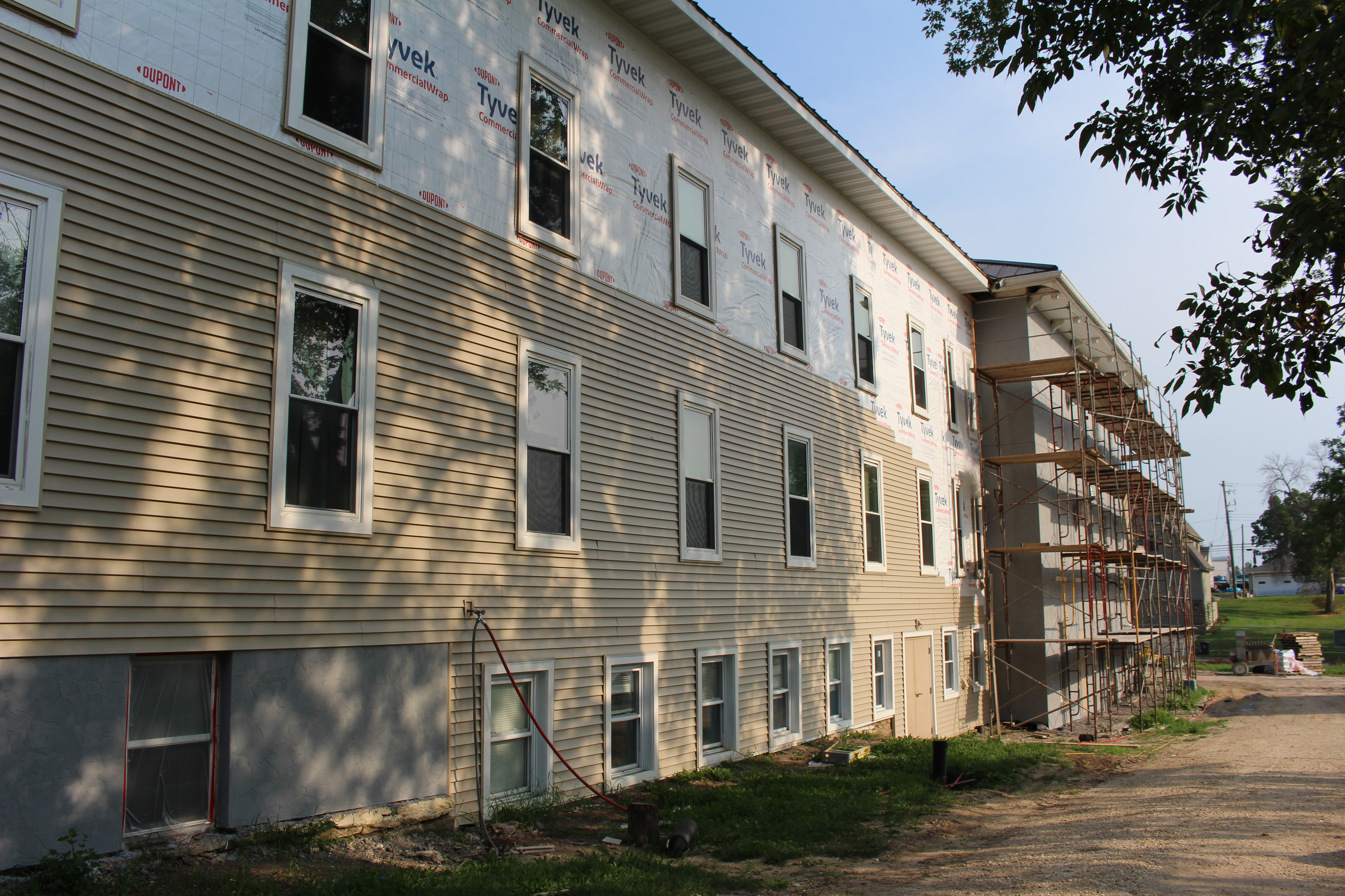 Building with partially installed siding and scaffolding