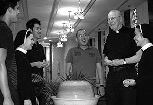 Fr Bill Shea laughing with Divine Word College students in the main chapel
