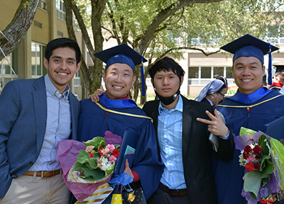 Four young men posing for a photo at graduation